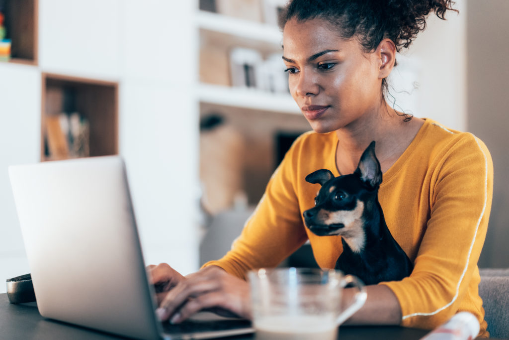 A woman working at a laptop and researching group benefits plans